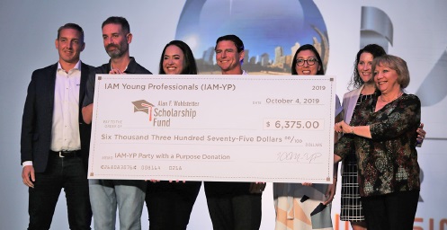 Maria Andrea Rodriguez receiving a donation from IAM Young Professionals.